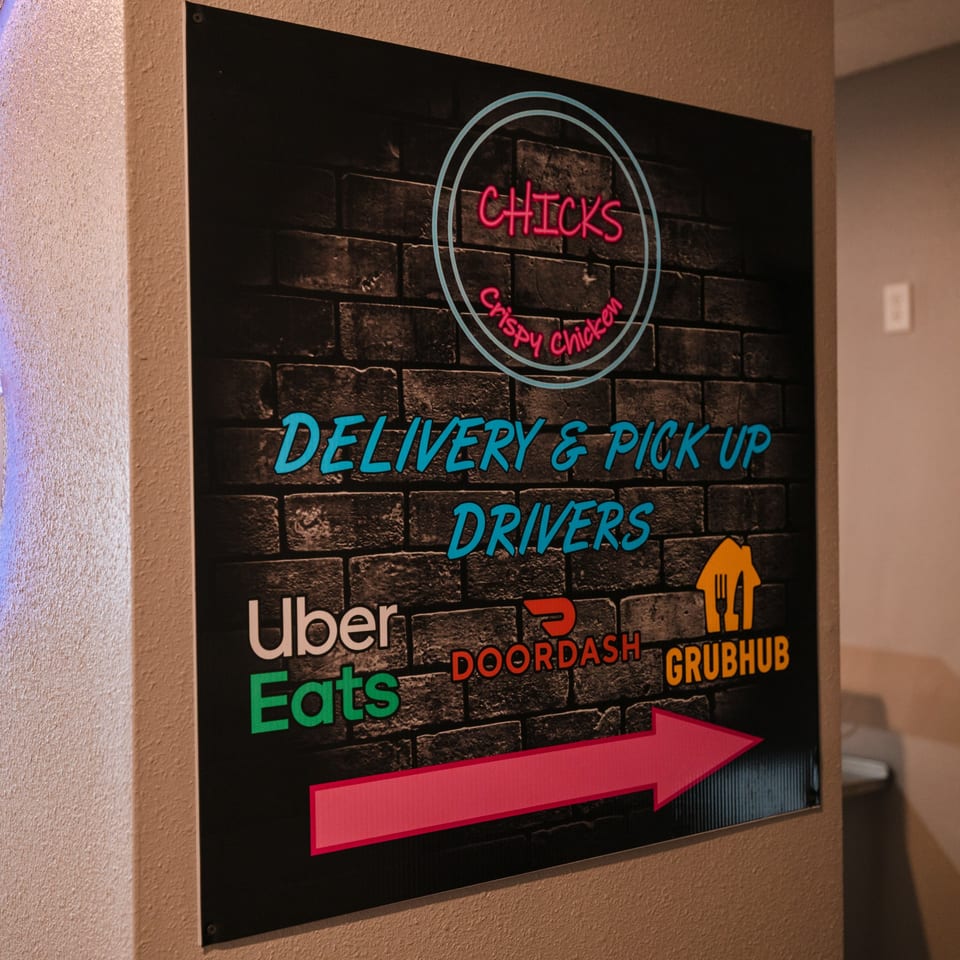 A Chicks Crispy Chicken sign for delivery and pick-up drivers, with logos for Uber Eats, DoorDash, and Grubhub.