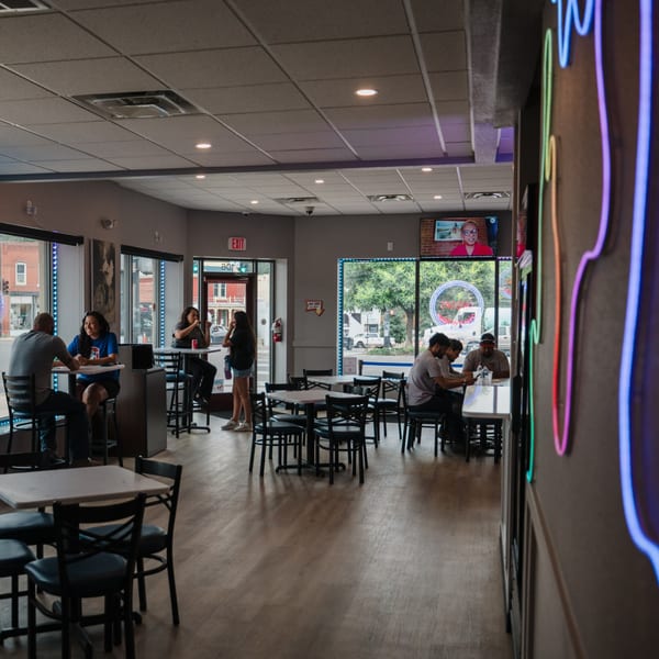 Customers dining and socializing in the casual, brightly lit interior of Chicks Chicken restaurant.