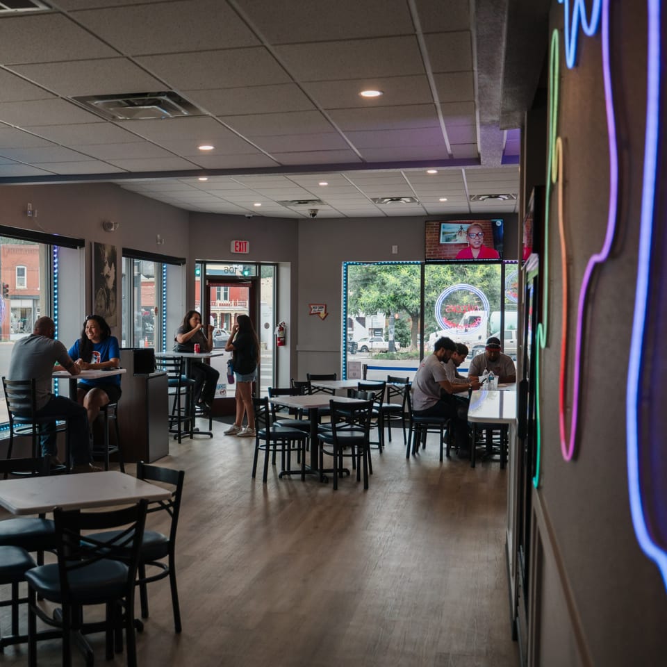 Customers dining and socializing in the casual, brightly lit interior of Chicks Chicken restaurant.